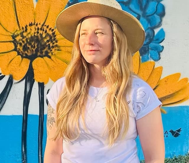 Andrea Holmes in front of her mural