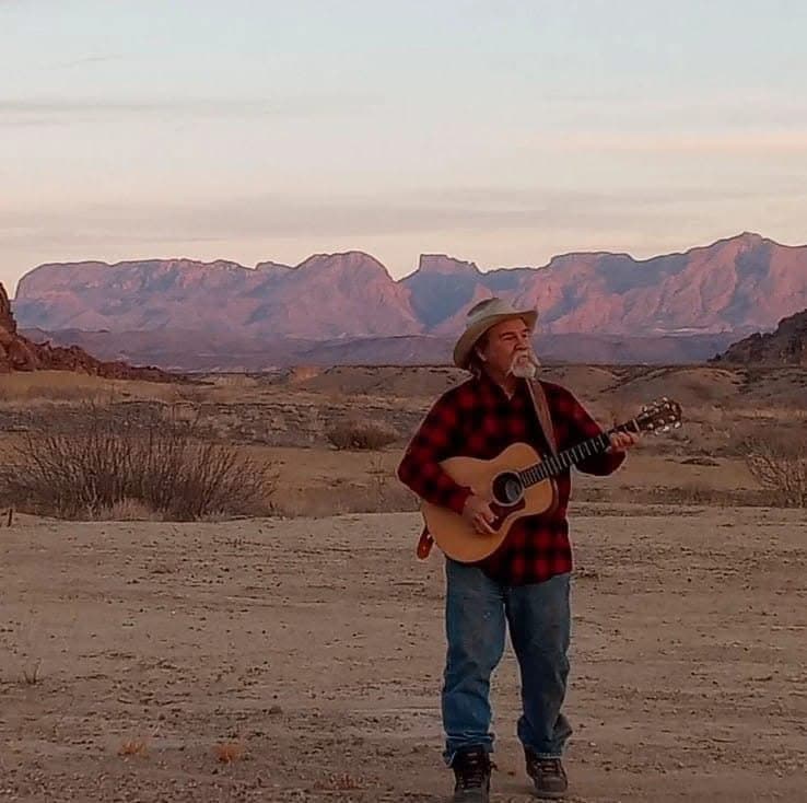 Portrait of Lee Haile with guitar in west texas