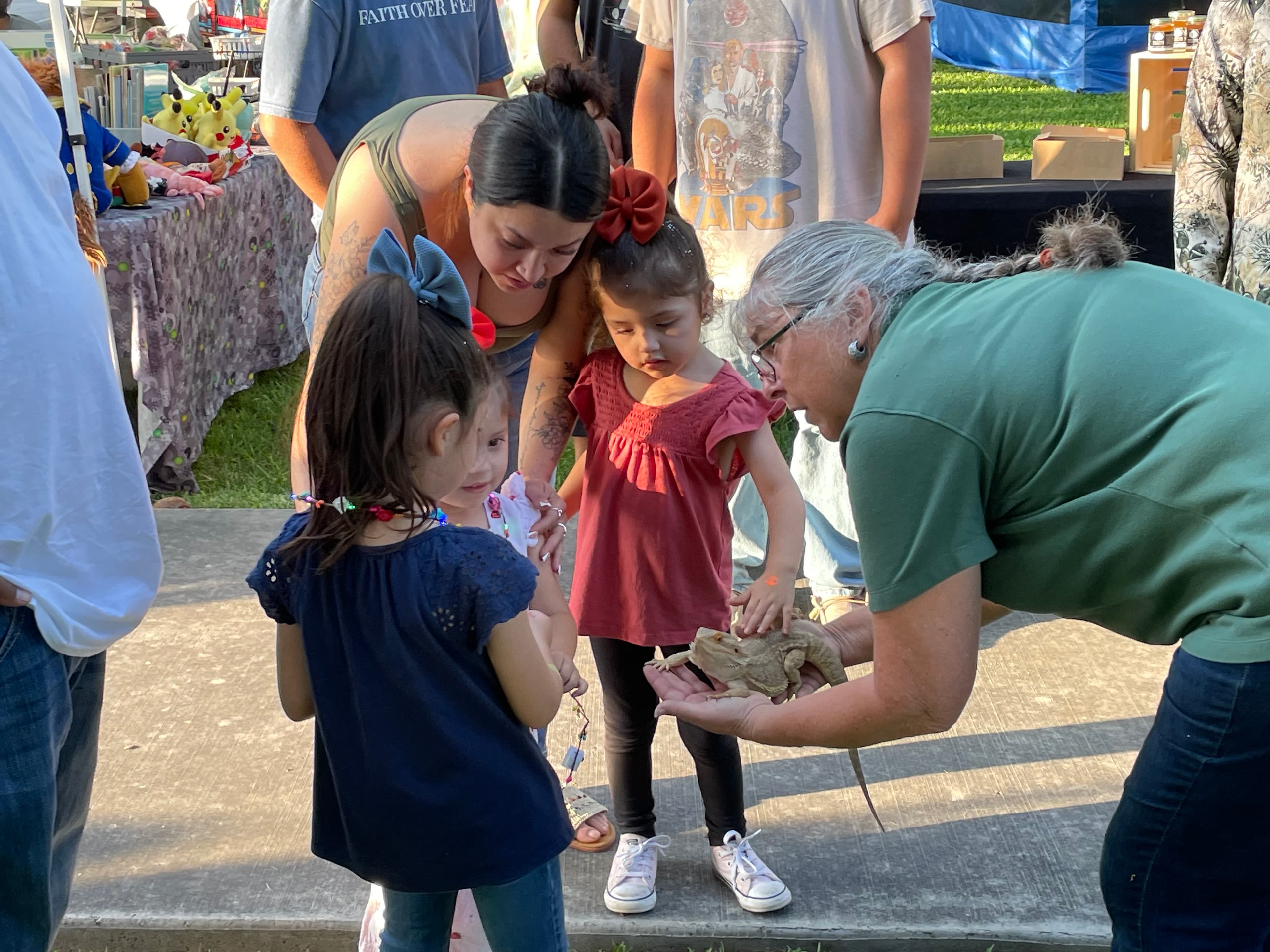 Texas Master Naturalist volunteer Kathy Rice showing a bearded dragon to small kids