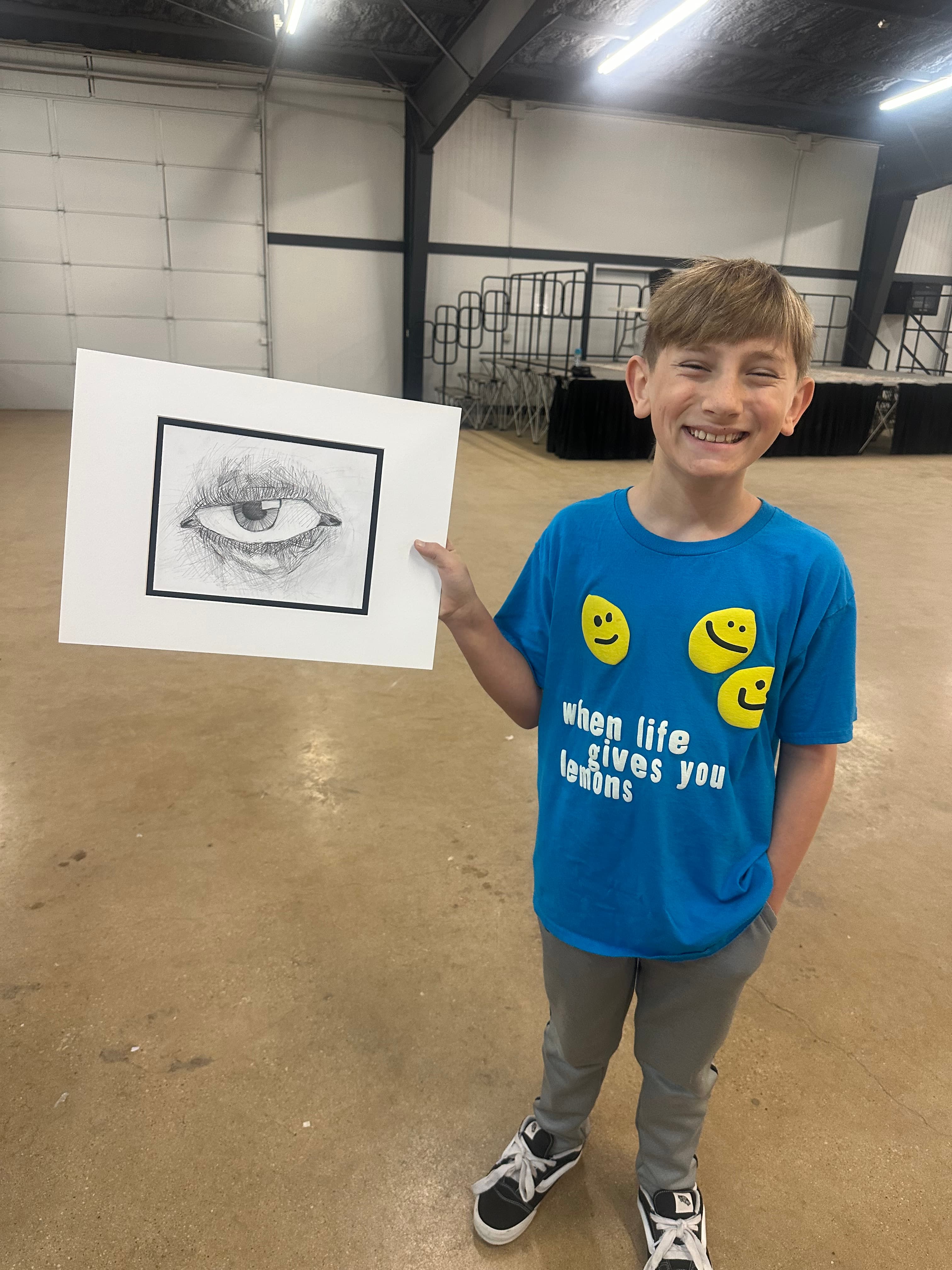 Heath holding a drawing of an eye